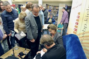 Na zdjęciu Adam Wajrak podpisuje książki.
